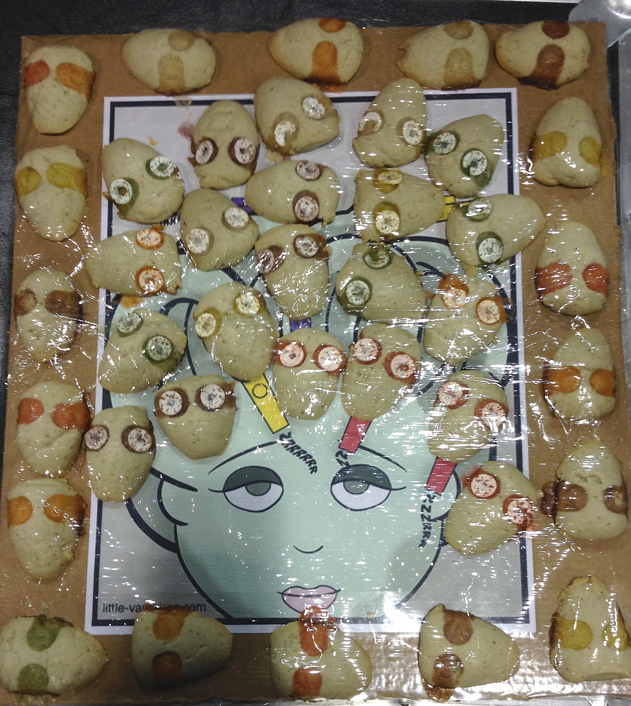 Photo of gorgonzola cookies in the shape of snakes' heads arranged on a drawing of Medusa by Rebecca Hicks