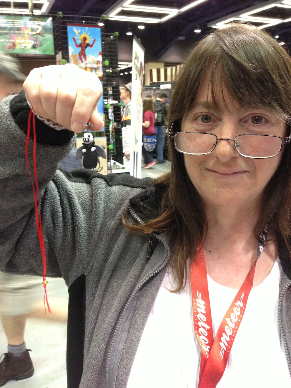 Photo of a mystery sculptor holding the Little Vampires necklace she sculpted