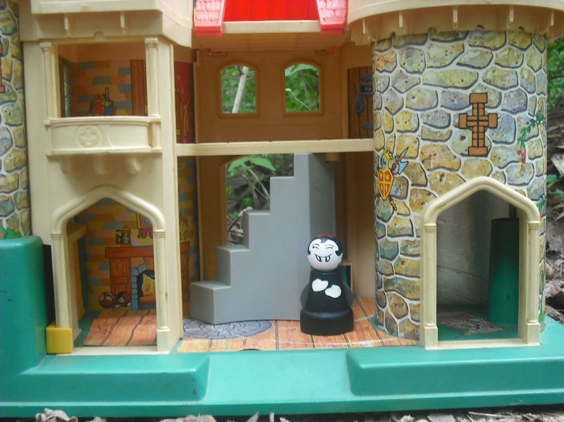 Photo of a Little Vampire girl wooden doll inside a toy castle