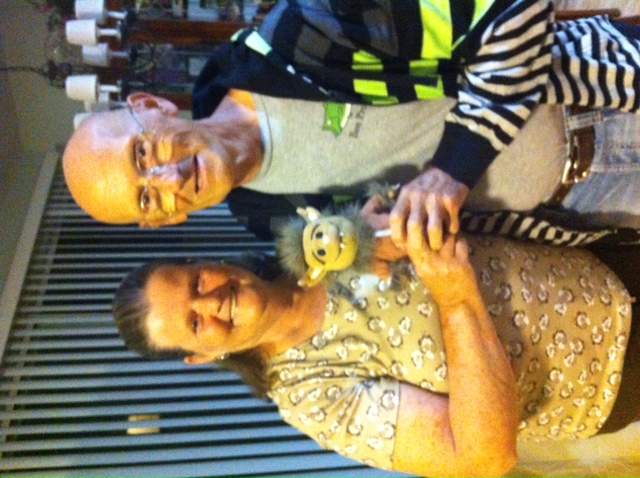 Photo of Mary and Charlie Farmer posing with a Wolfie plush toy