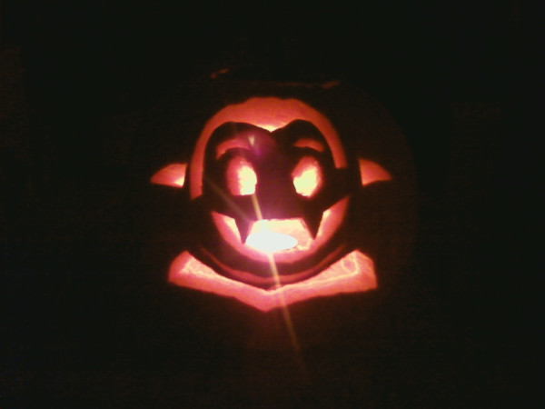 Photo of a lit Little Vampire jack o' lantern in the dark