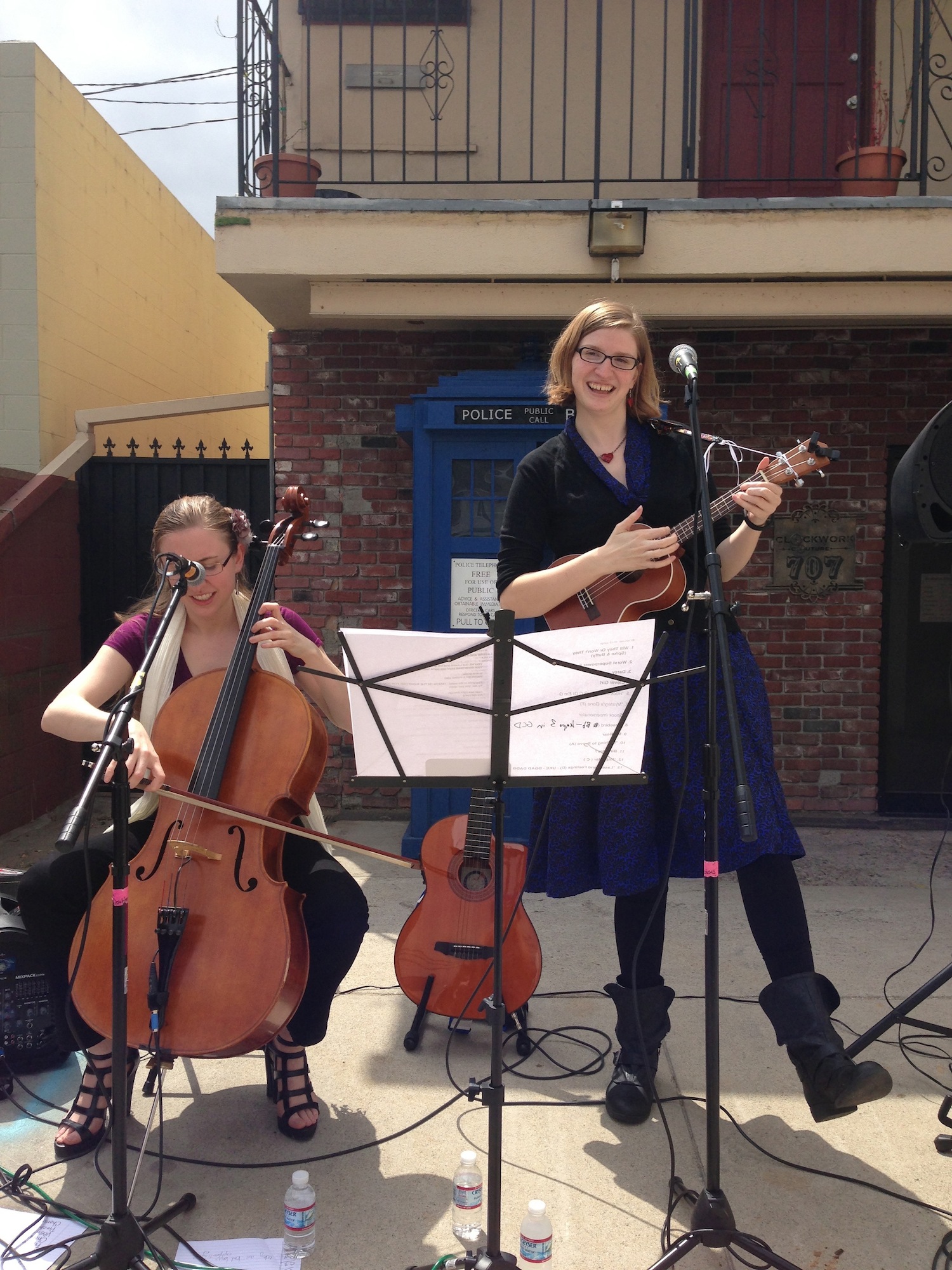 Photo of the Doubleclicks performing outdoors in front of a TARDIS