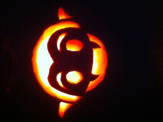 Photo of a lighted Little Vampires jack-o'-lantern in darkness