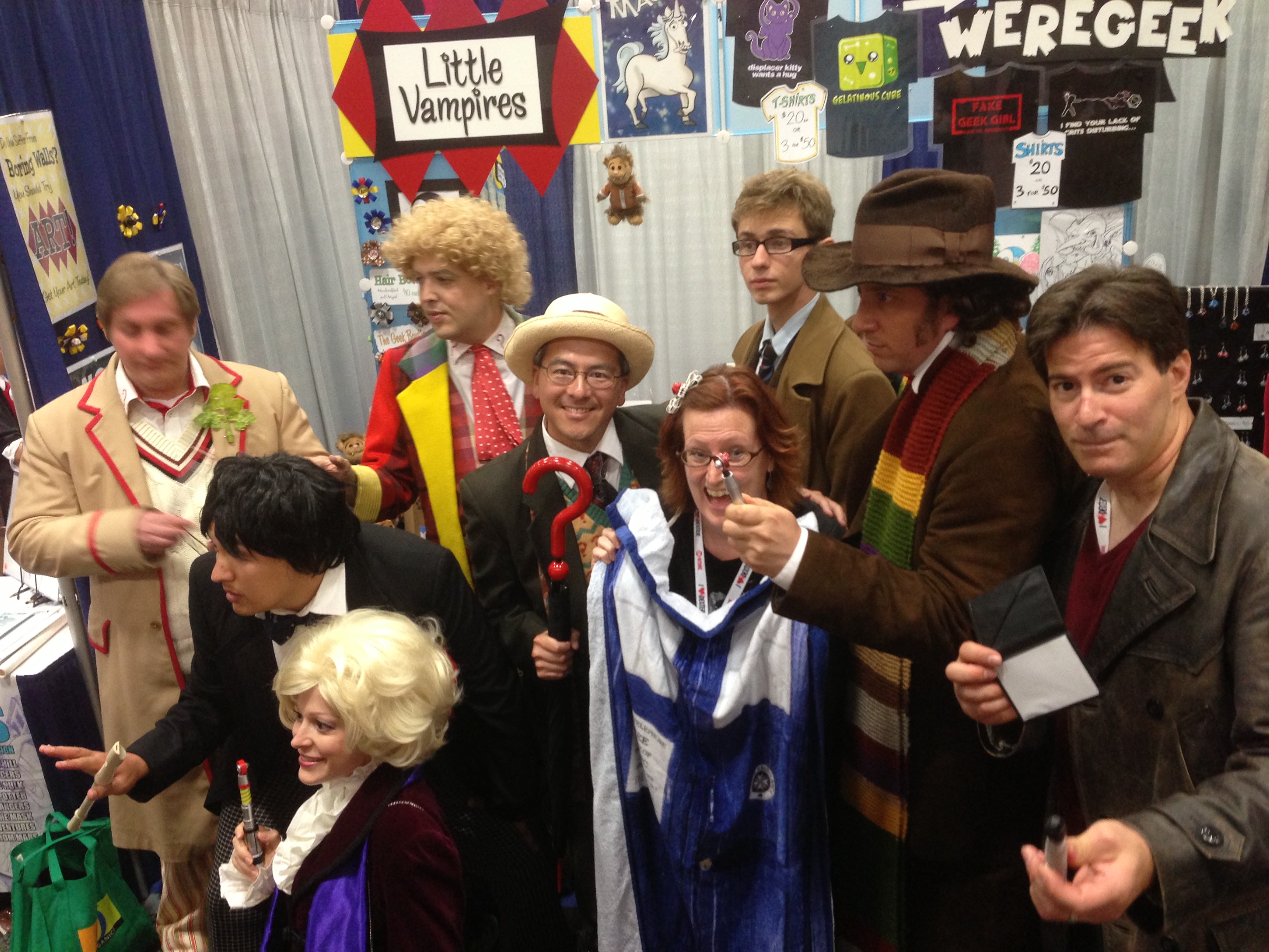 Rebecca Hicks posing with several Doctor Who cosplayers in front of the Little Vampures booth