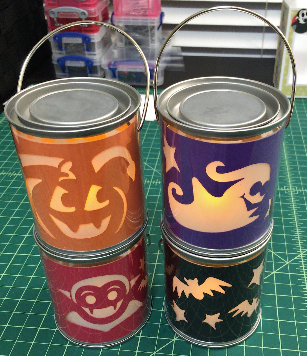Photo of mini paint bucket lanterns featuring a jack o' lantern, a ghost, a Little Vampire, and bats
