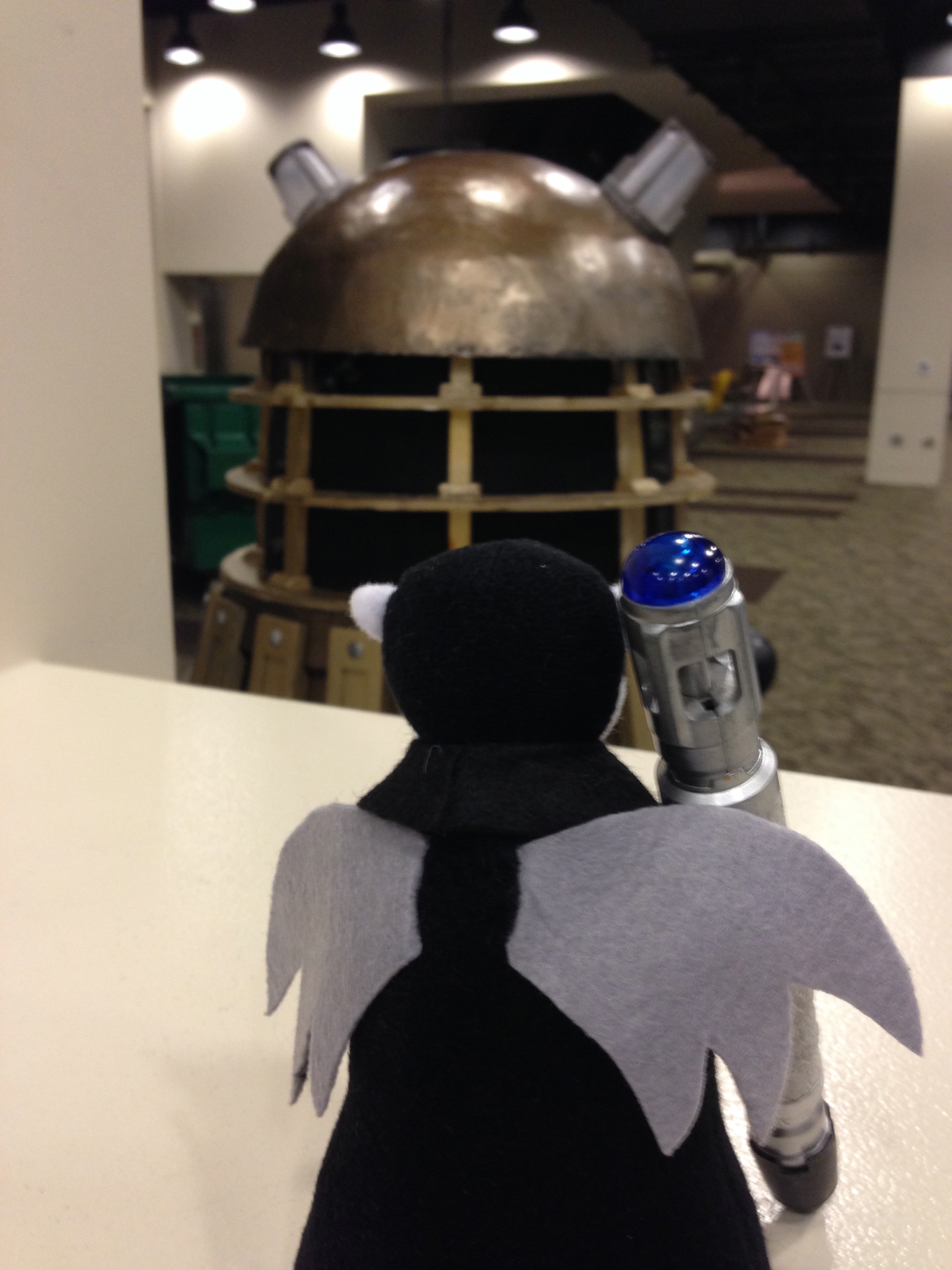 Photo of a Little Vampire plush toy with a sonic screwdriver posing in front of a Dalek